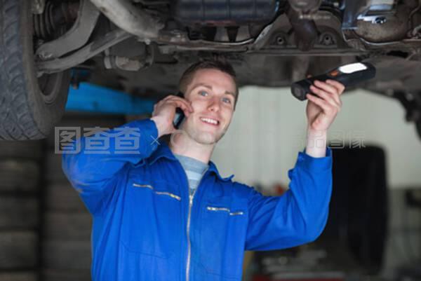 使用手機的汽車修理工